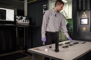 Man inspecting turbine blades on a countertop.